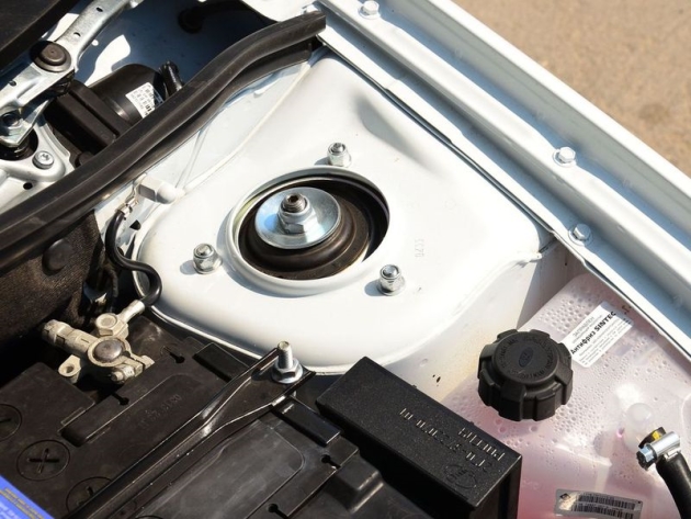 Смещенный от центра шток амортизатора выдает стойки с увеличенным углом кастера. Сам амортизатор теперь крепится к опорной чашке через дополнительную усиливающую пластину. Кстати, видите слева механизм стеклоочистителей? Тут тоже перемены: электромоторы теперь поставляет фирма Valeo.